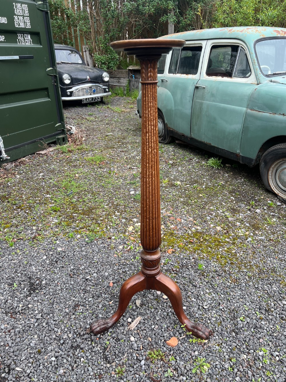 A tall nineteenth-century mahogany pedestal stand featuring a fluted column, acanthus leaf carving, and a tripod base with carved feet. View VI