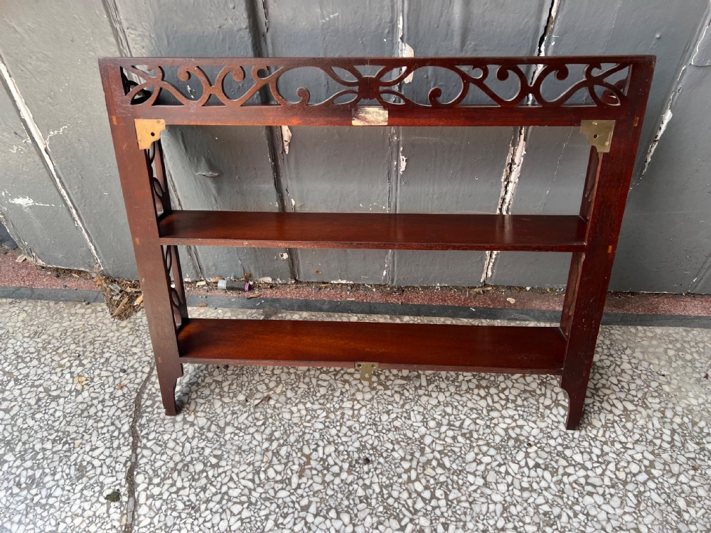 A three-tier dark mahogany wall shelf featuring decorative lattice fretwork side panels and a carved top gallery. View IV