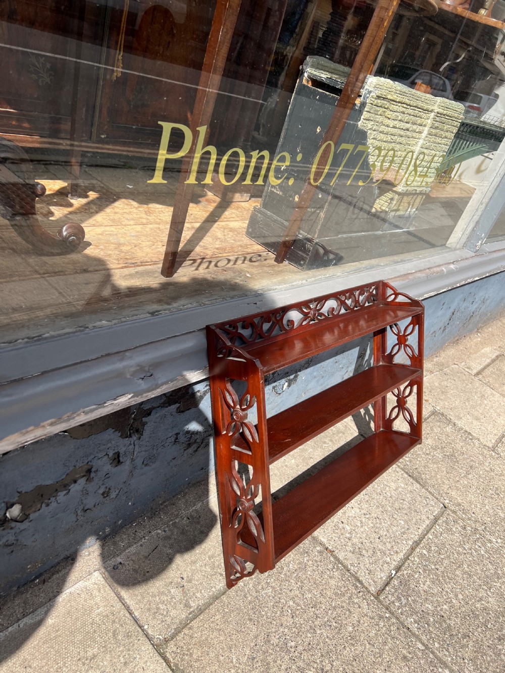 A three-tier dark mahogany wall shelf featuring decorative lattice fretwork side panels and a carved top gallery. View VII