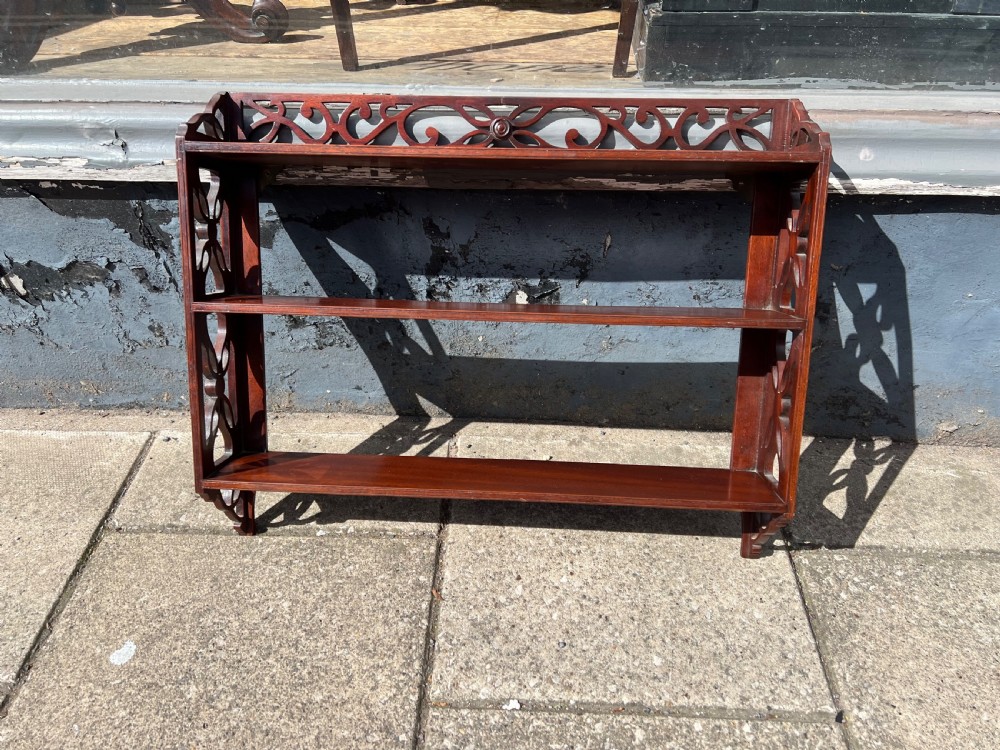 A three-tier dark mahogany wall shelf featuring decorative lattice fretwork side panels and a carved top gallery. View IX