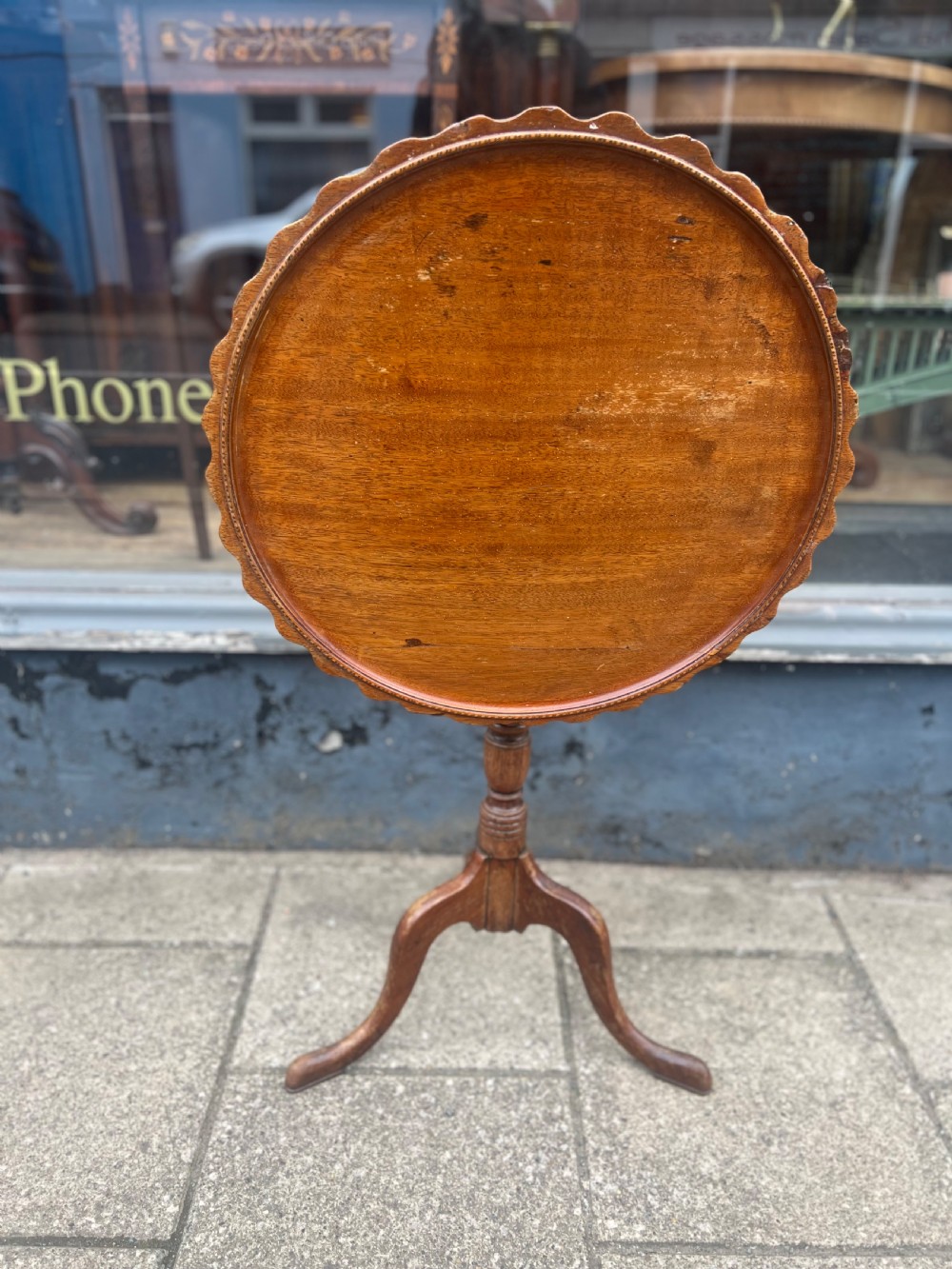 A nineteenth-century dark wood tripod wine table featuring a scalloped rim top, a turned central column, and three cabriole legs. View III