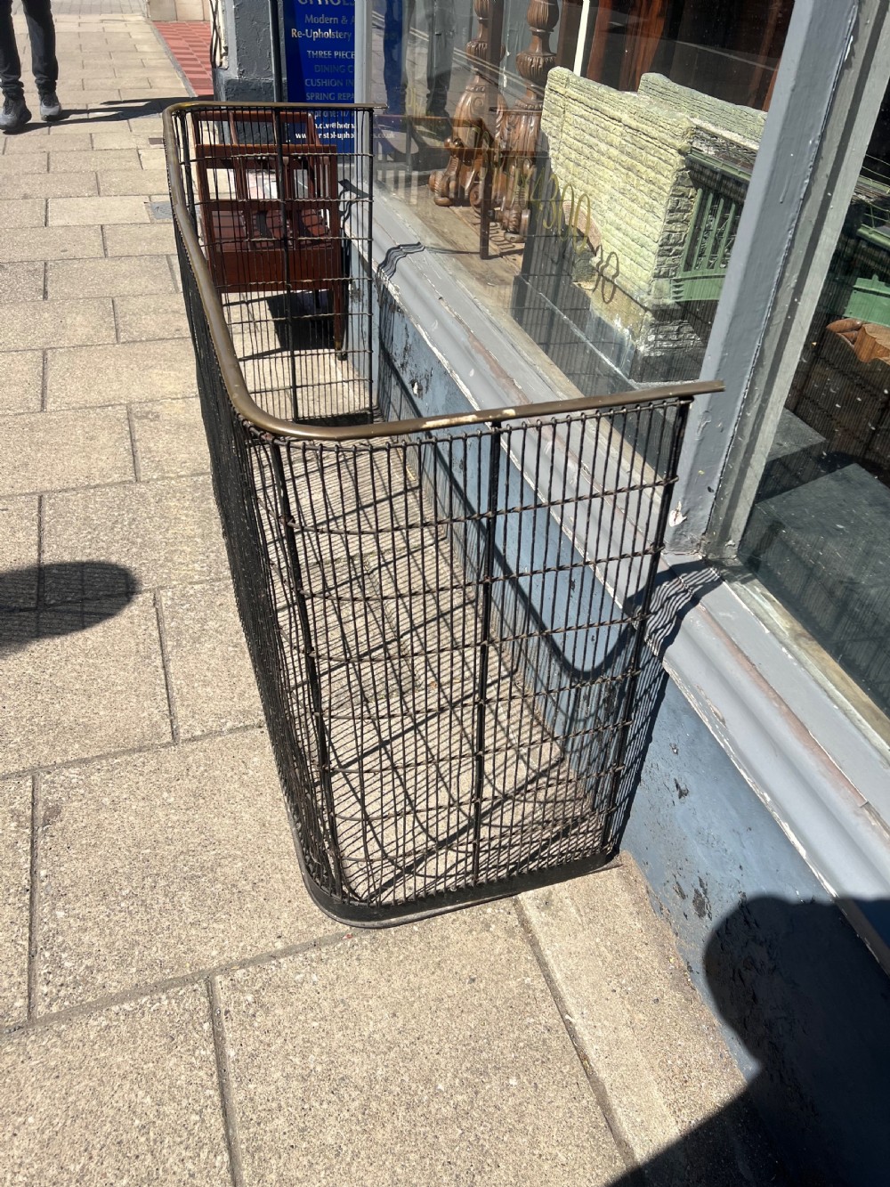 A nineteenth-century curved nursery fender constructed with vertical iron wire mesh and a fitted brass top rail. View II