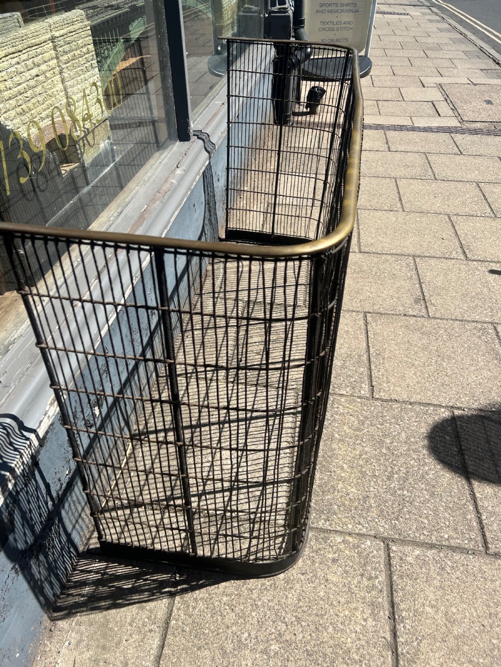 A nineteenth-century curved nursery fender constructed with vertical iron wire mesh and a fitted brass top rail. View III
