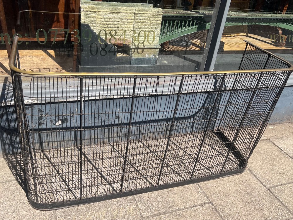 A nineteenth-century curved nursery fender constructed with vertical iron wire mesh and a fitted brass top rail. View IV