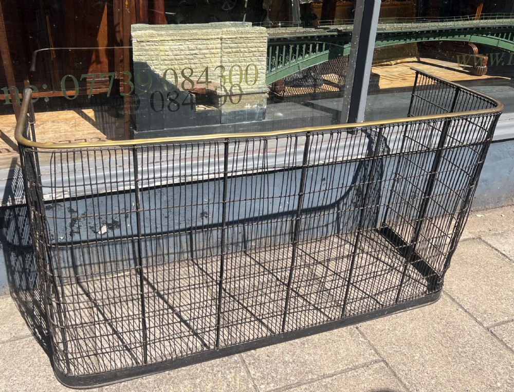 A nineteenth-century curved nursery fender constructed with vertical iron wire mesh and a fitted brass top rail. View V