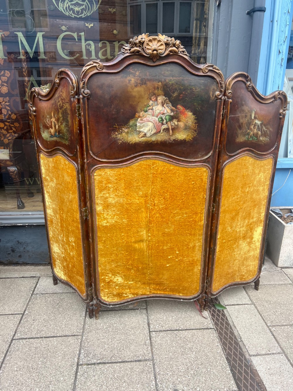 A three-panel French modesty screen featuring carved timber frames with oil-painted pastoral scenes on the upper panels and gold velvet upholstery on the lower panels. View IX