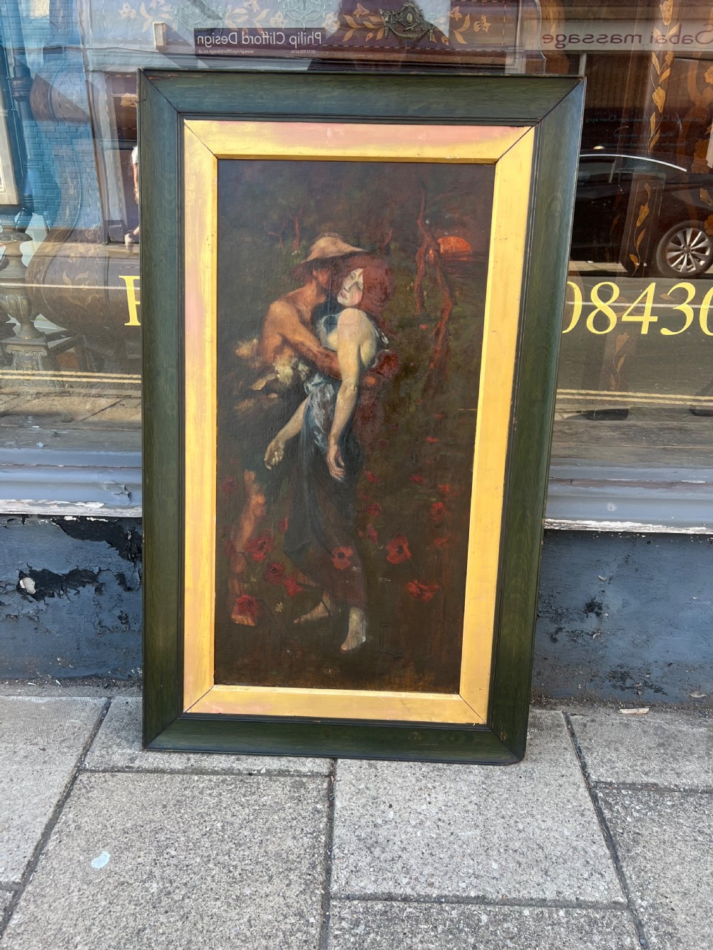 A vertical oil painting on canvas depicting two figures embracing amongst red poppies, housed in a wide green timber frame with a gilt inner slip. View II