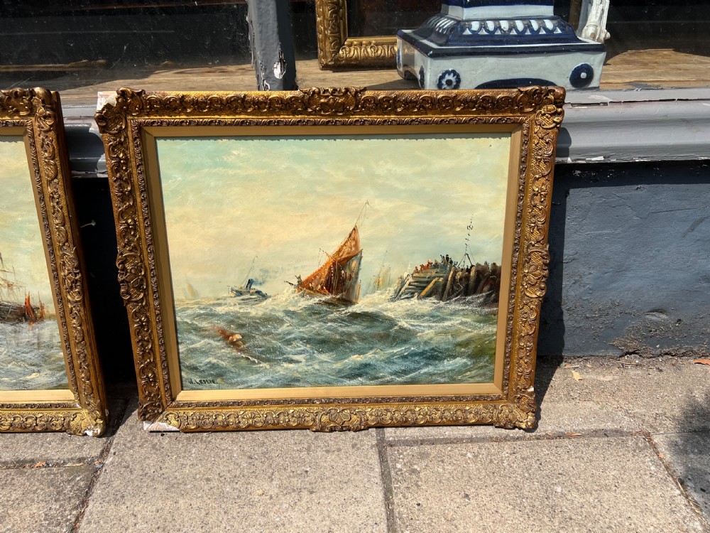 A pair of antique oil paintings on board depicting sailing ships on choppy waters, framed in ornate gold gilt frames. View II