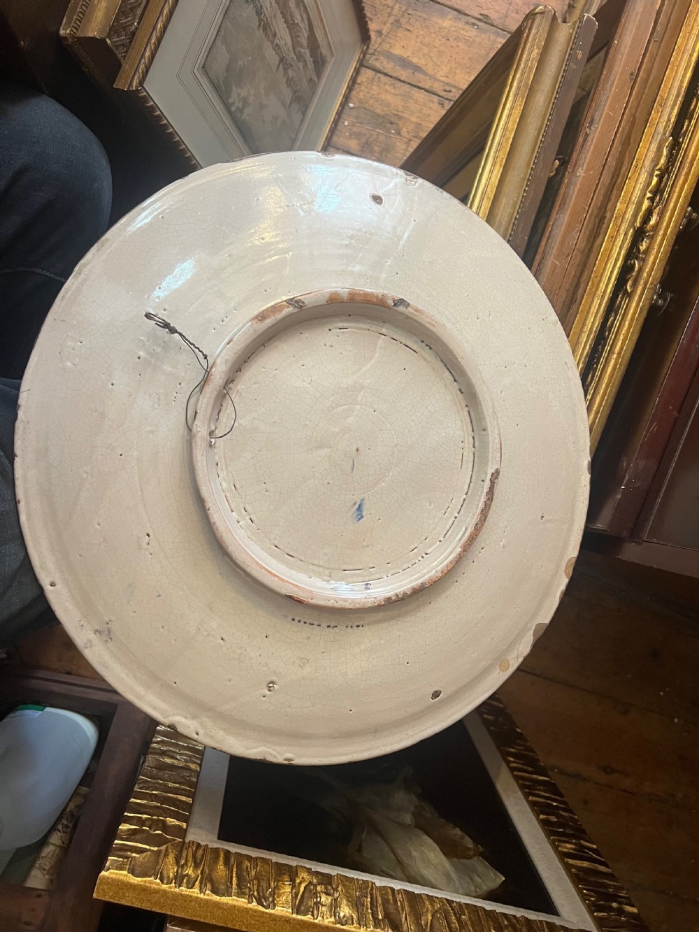A circular Italian maiolica charger featuring a hand-painted istoriato narrative scene with classical figures around a well in ochre, green, and blue tones. View II