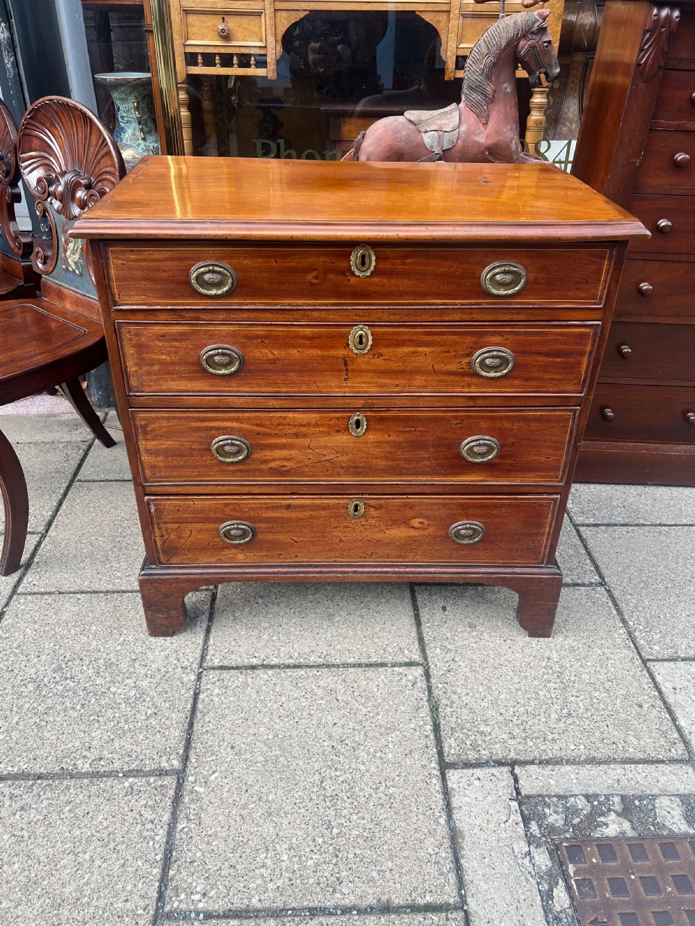 A Georgian mahogany chest of drawers with four full-width drawers, oval brass handles, brass escutcheons, and bracket feet. View III