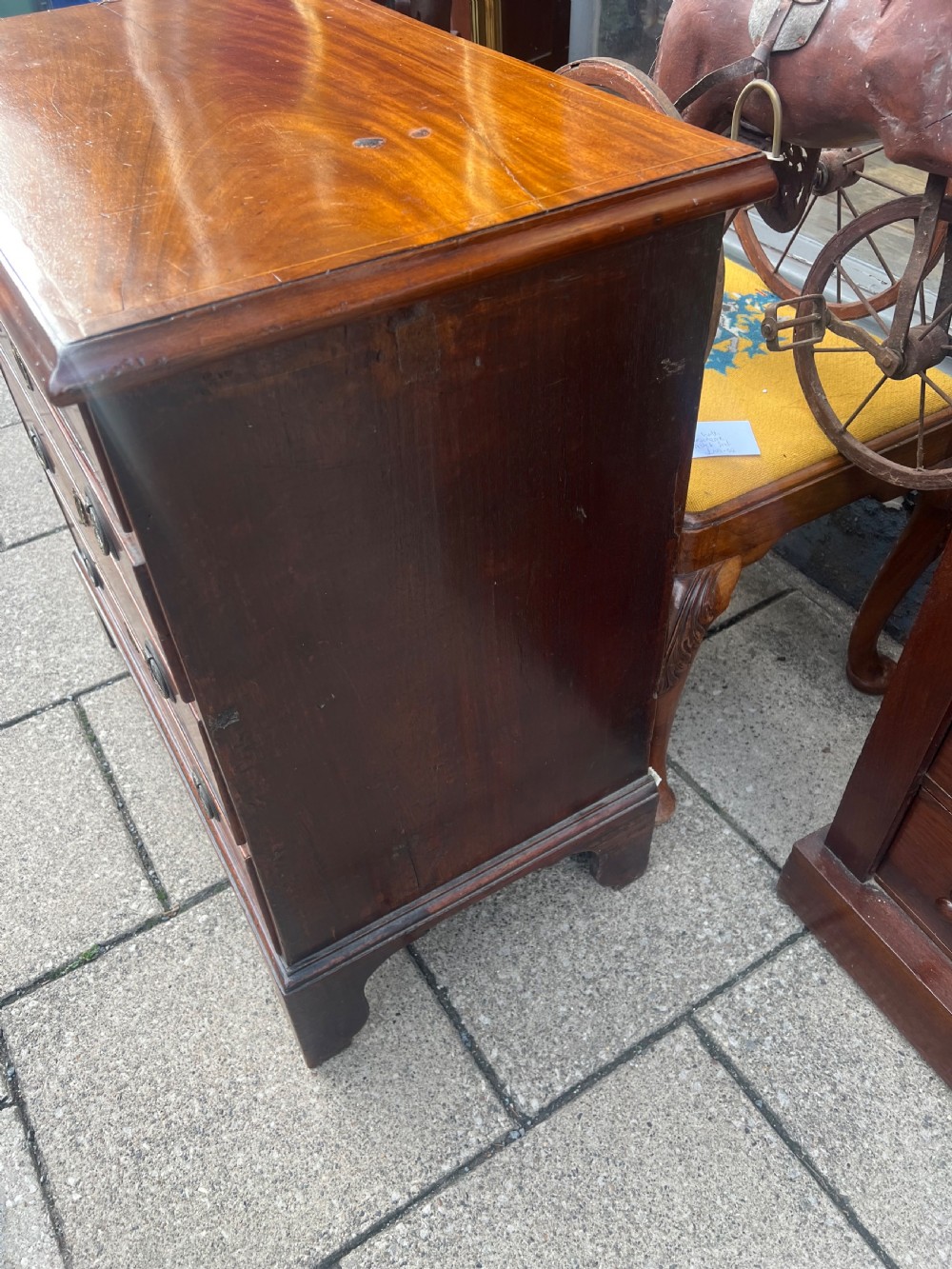 A Georgian mahogany chest of drawers with four full-width drawers, oval brass handles, brass escutcheons, and bracket feet. View VI