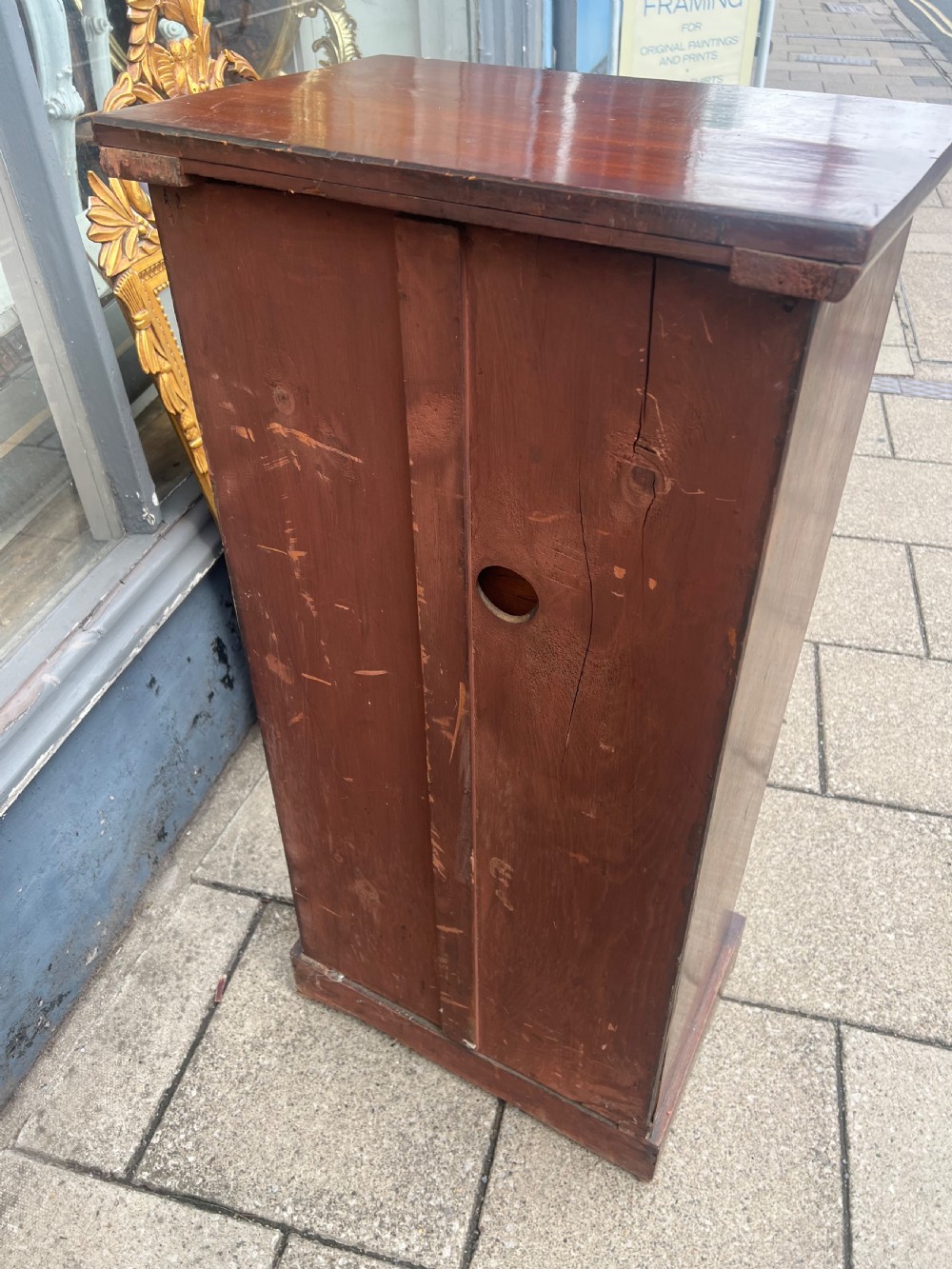 A tall, narrow Victorian walnut Wellington chest featuring seven stacked drawers with wooden turned knobs and carved leaf corbels at the top sides. View II