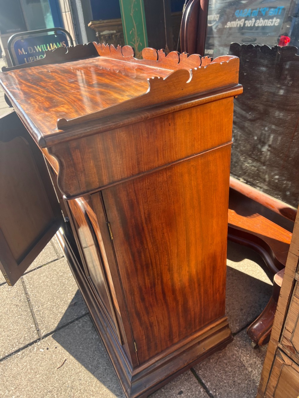 A William IV flame mahogany side cabinet with twin arch-panelled doors, a cushion frieze drawer, and a shaped gallery top rail. View VI