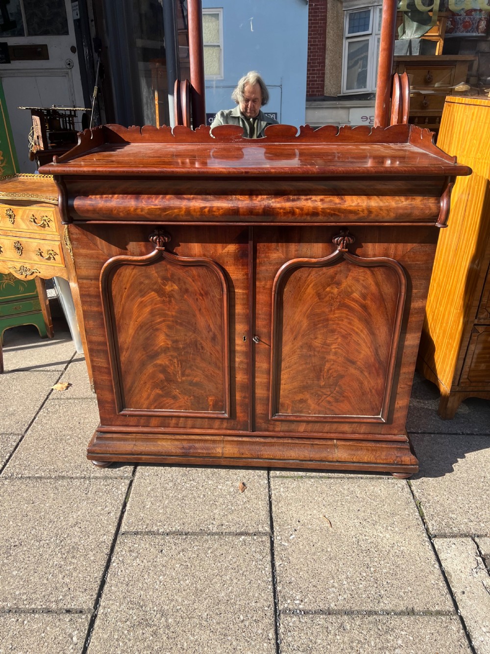 A William IV flame mahogany side cabinet with twin arch-panelled doors, a cushion frieze drawer, and a shaped gallery top rail. View IX