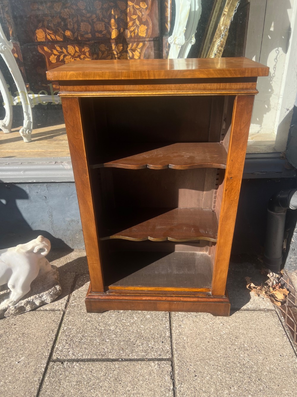 A small nineteenth-century mahogany open bookcase featuring three tiers with shaped shelf fronts and a plinth base. View VI