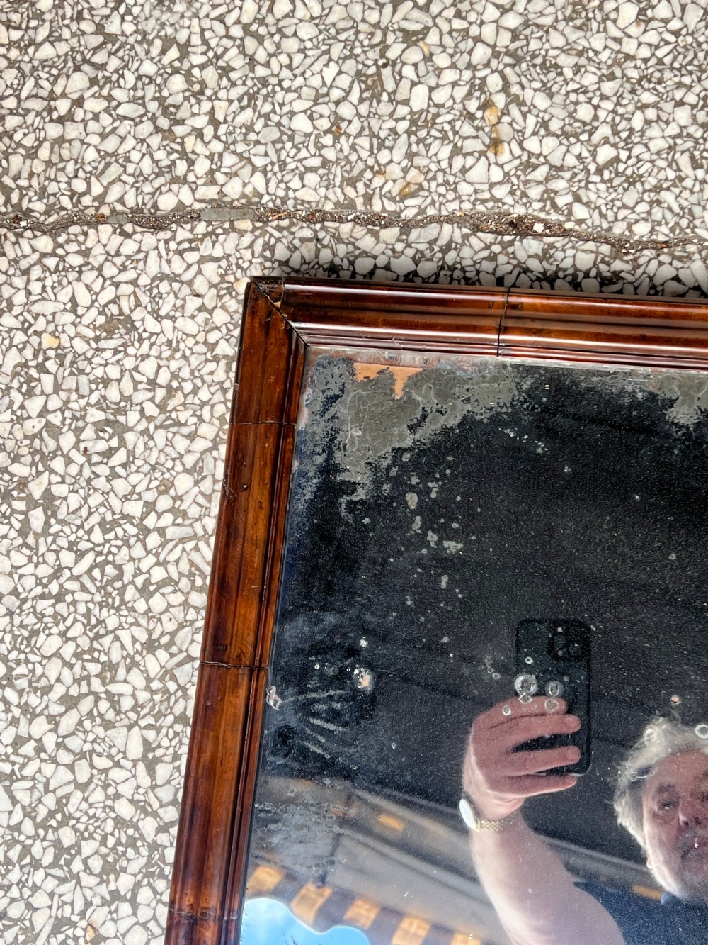 A rectangular 18th-century wall mirror featuring a moulded warm brown walnut wood frame enclosing heavily foxed and distressed glass. View V