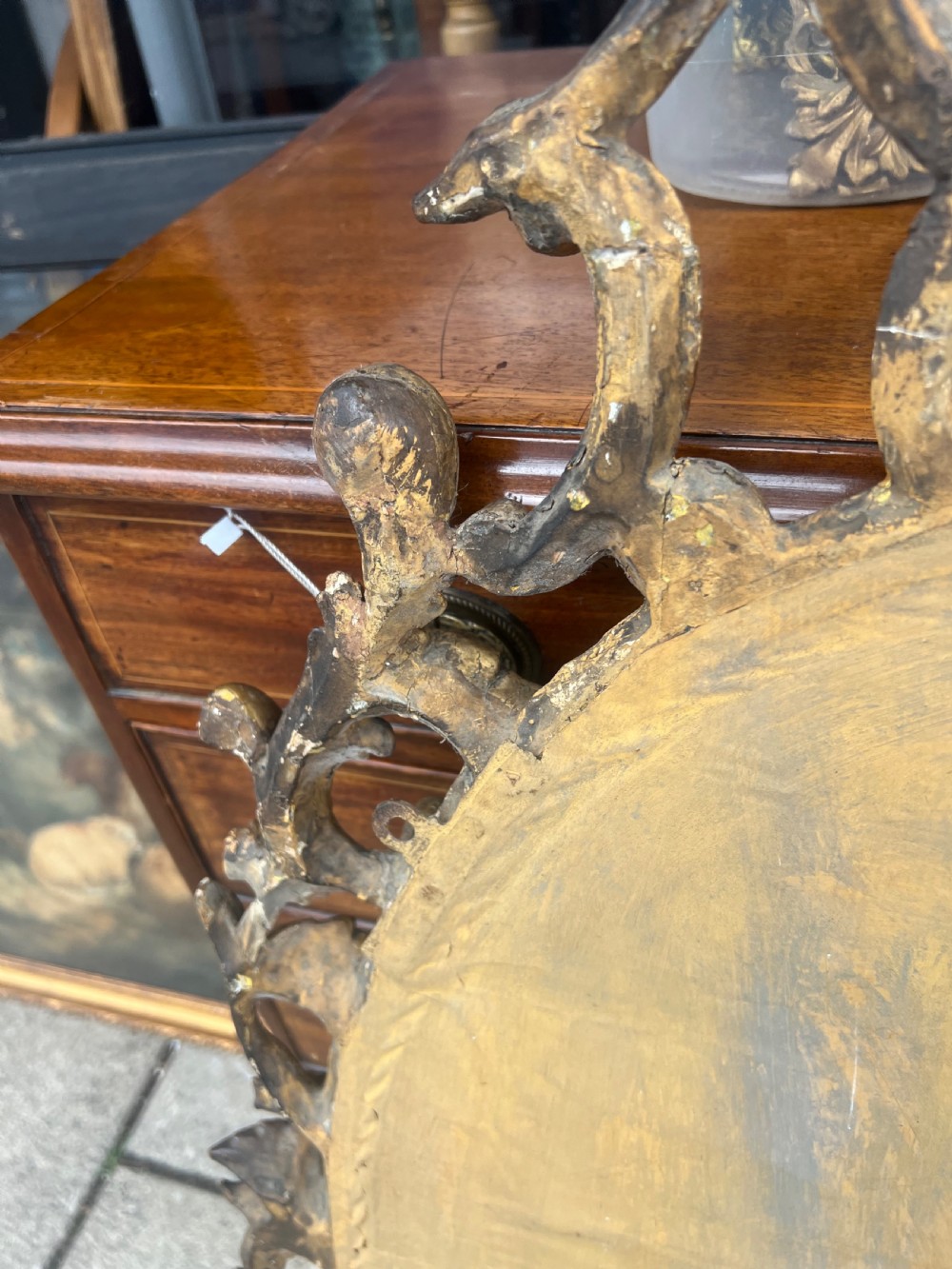 An 18th-century style oval wall mirror featuring a carved giltwood frame with openwork scrollwork and acanthus leaf cresting. View IV