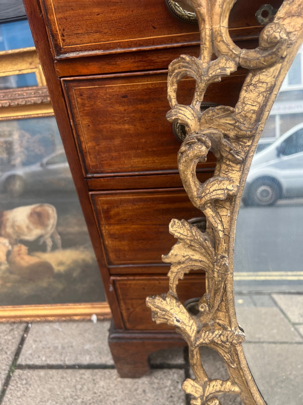 An 18th-century style oval wall mirror featuring a carved giltwood frame with openwork scrollwork and acanthus leaf cresting. View VII
