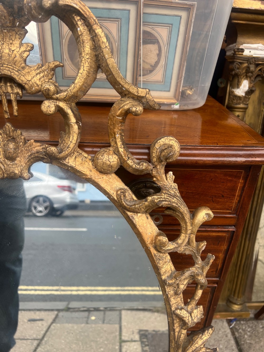 An 18th-century style oval wall mirror featuring a carved giltwood frame with openwork scrollwork and acanthus leaf cresting. View X