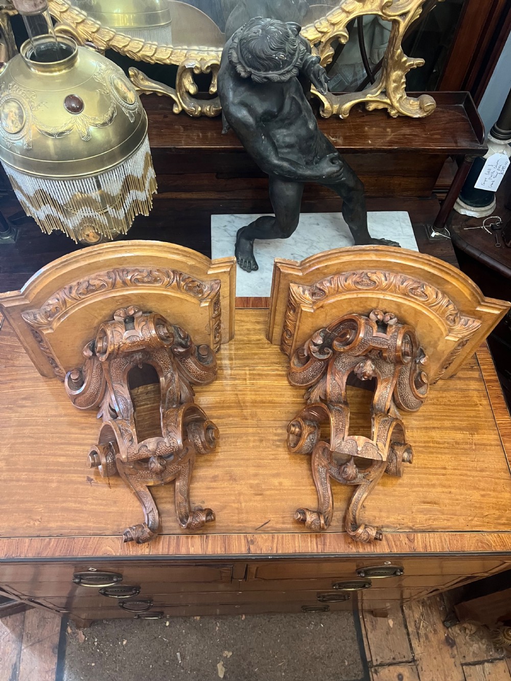 A matching pair of Georgian carved walnut wall brackets featuring intricate scrollwork and acanthus leaf detailing. View II