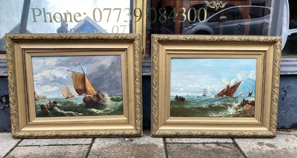 A pair of antique seascape oil paintings depicting sailing ships on choppy ocean waves, housed in matching gilt gesso frames. View II
