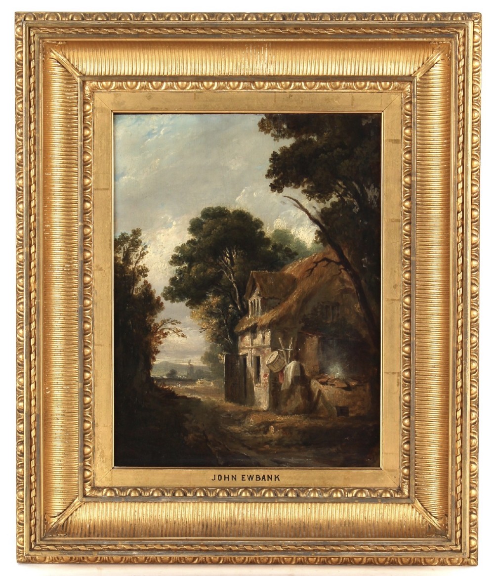 A 19th-century oil painting depicting a thatched cottage beside a dirt track with a distant windmill, set within a heavily moulded gilded frame.