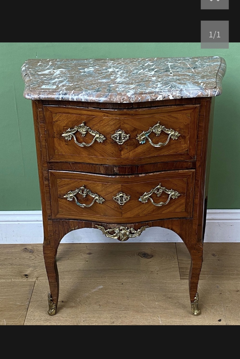 A 19th-century French two-drawer chest featuring a shaped pink marble top, geometric wood veneer inlay, curved cabriole legs, and decorative brass mounts. View II
