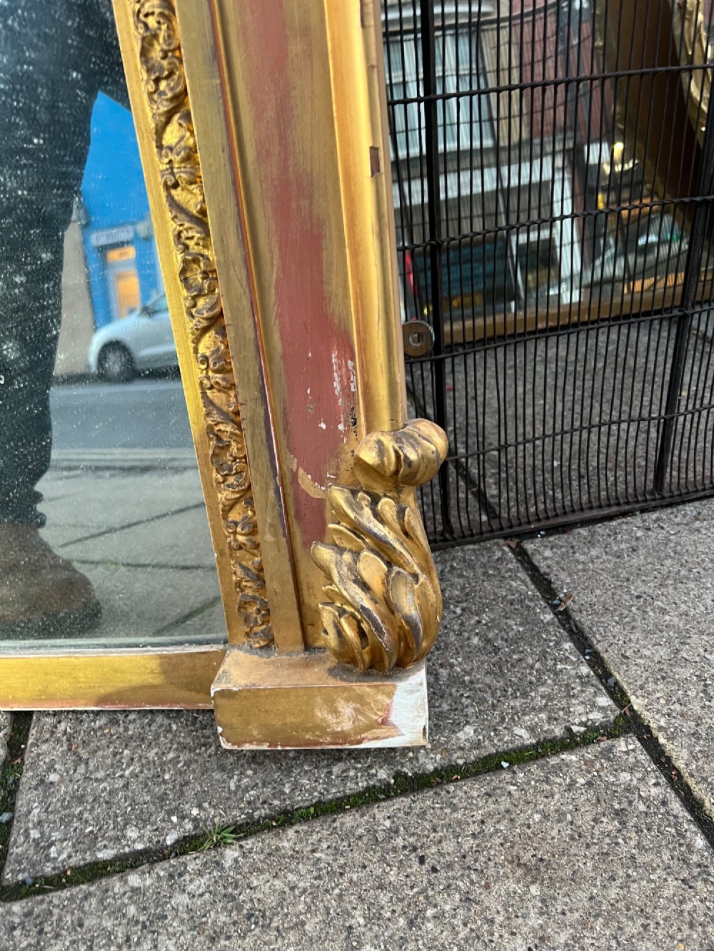 An ornate antique giltwood overmantel mirror featuring a carved acanthus leaf cresting and a decorative beaded inner frame. View III