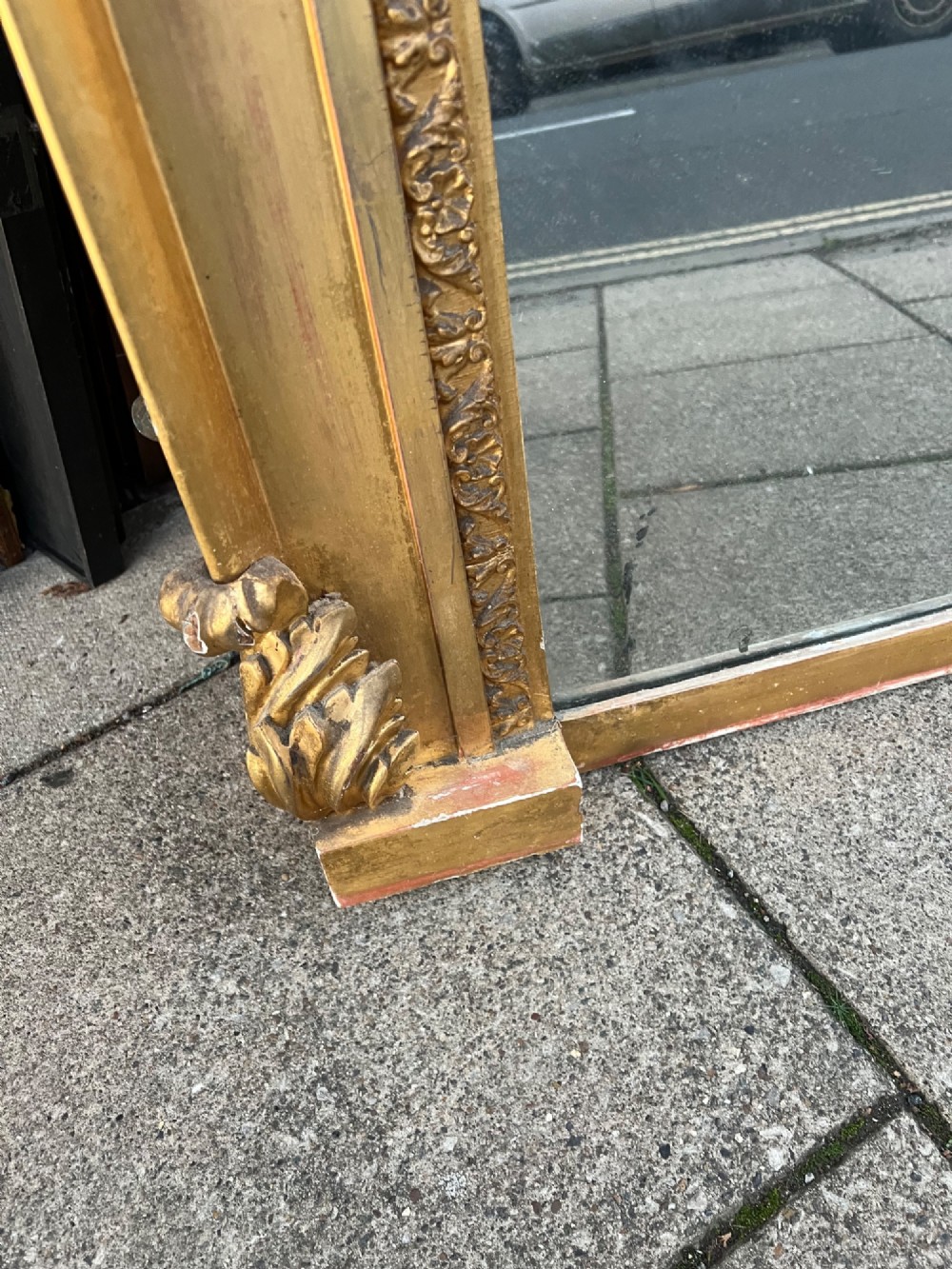 An ornate antique giltwood overmantel mirror featuring a carved acanthus leaf cresting and a decorative beaded inner frame. View IV