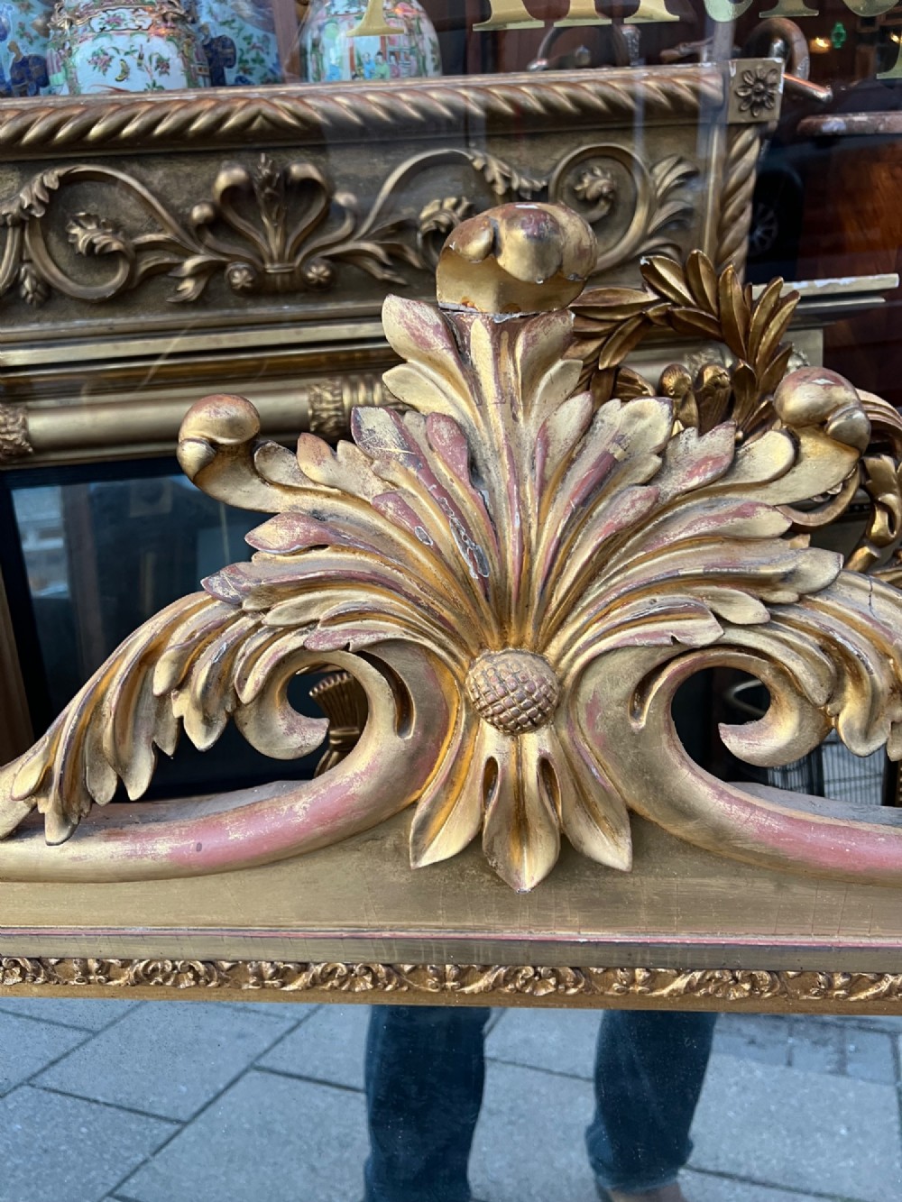 An ornate antique giltwood overmantel mirror featuring a carved acanthus leaf cresting and a decorative beaded inner frame. View VII