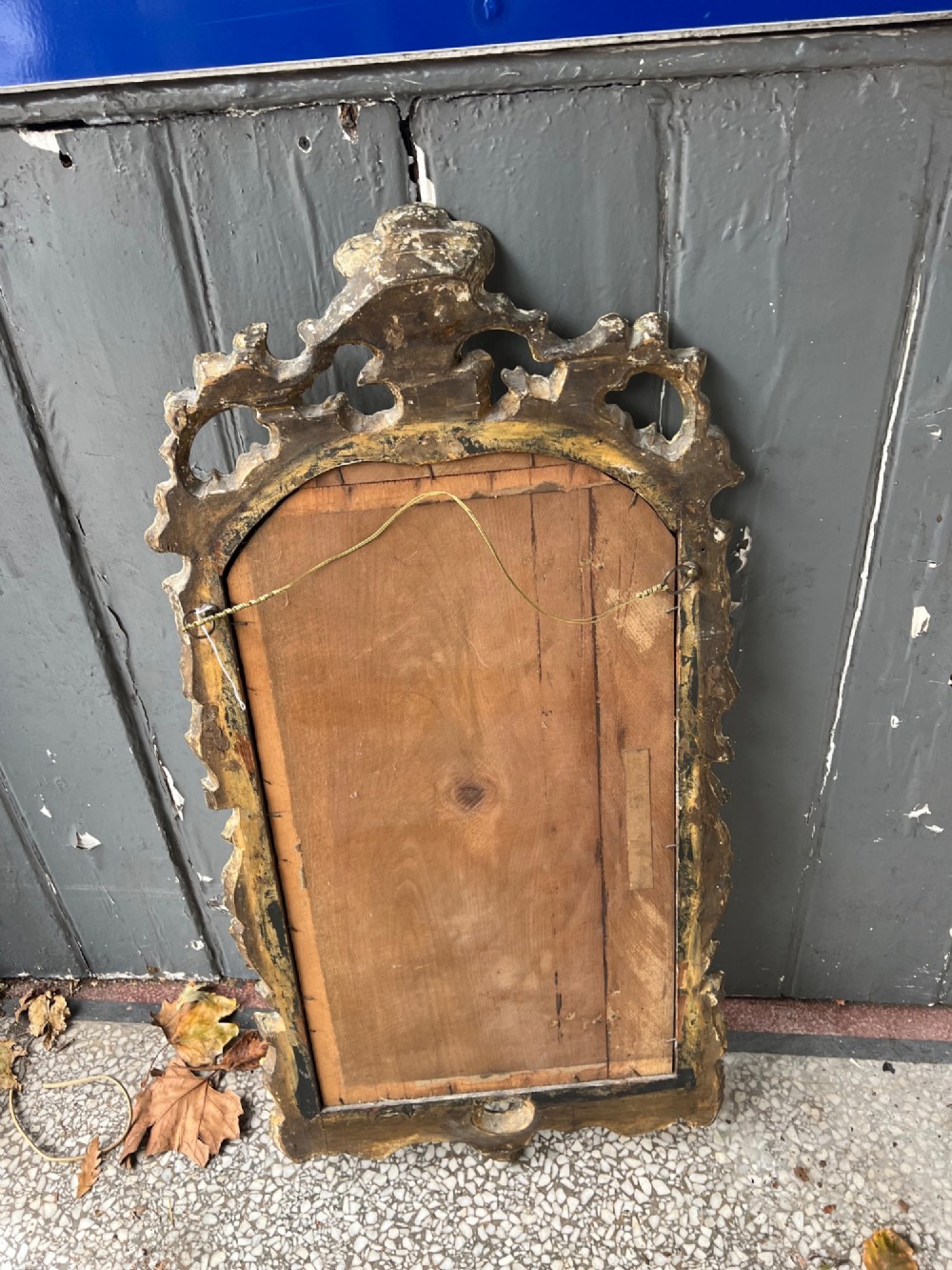 An 18th-century style wall mirror featuring an ornate carved gold giltwood frame with pierced cresting and acanthus leaf detail surrounding a shaped glass pane. View IV