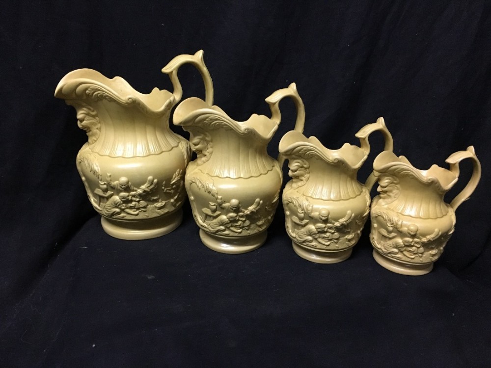C19th graduated set of stoneware jugs depicting monkeys