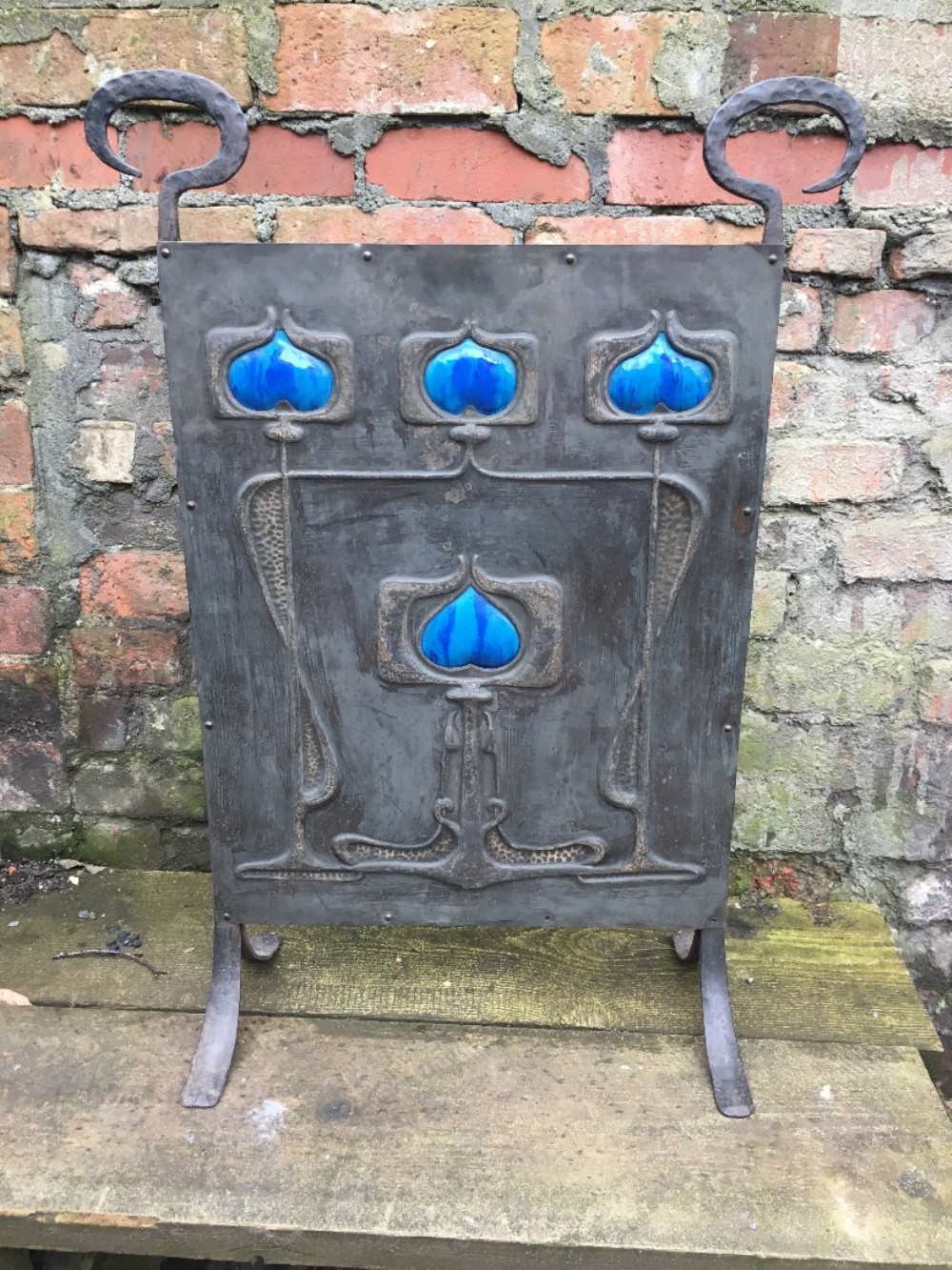 Arts and crafts steel fire screen with ceramic heart inlays.