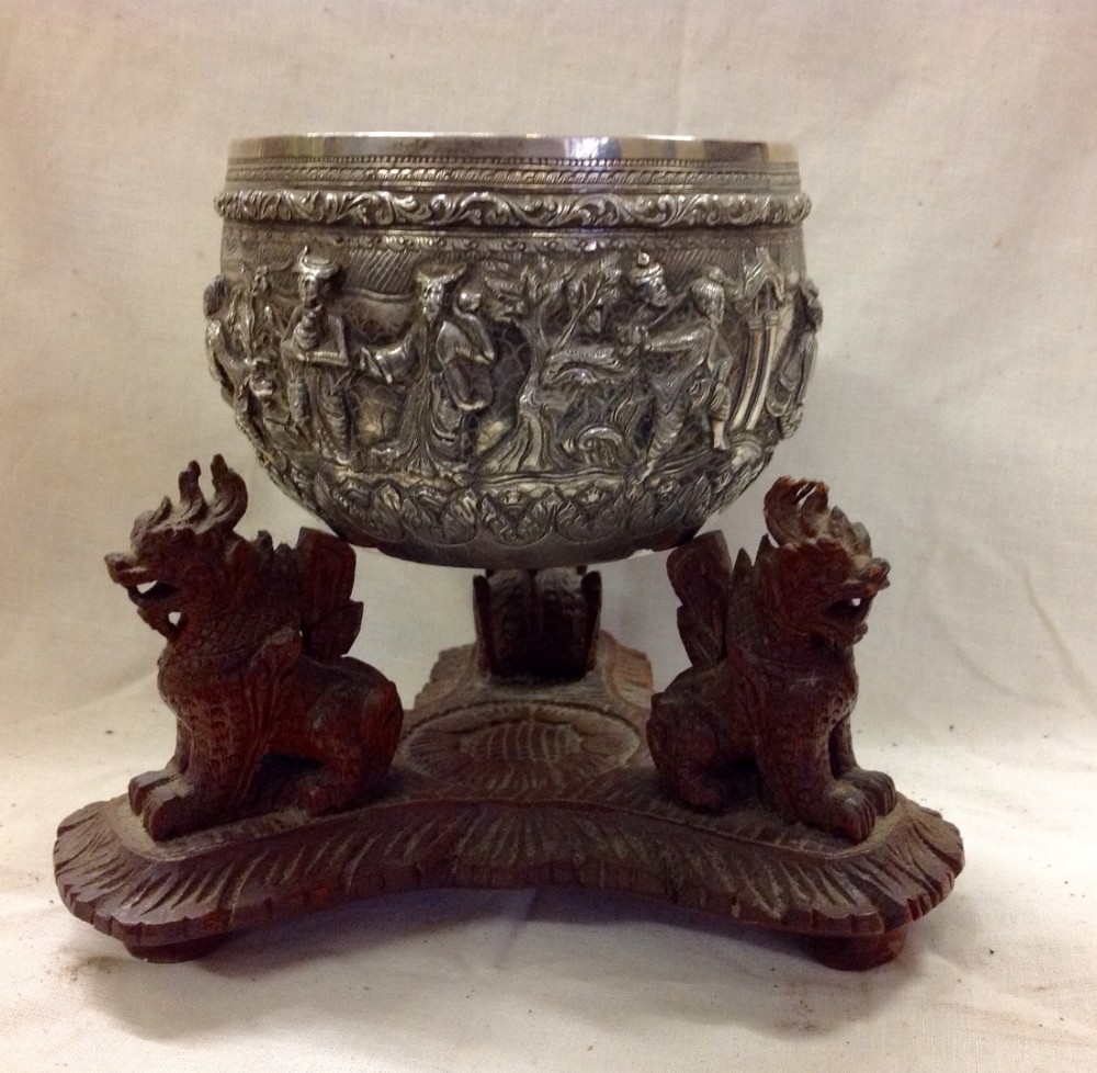 C19th Burmese silver cast bowl on a wooden stand