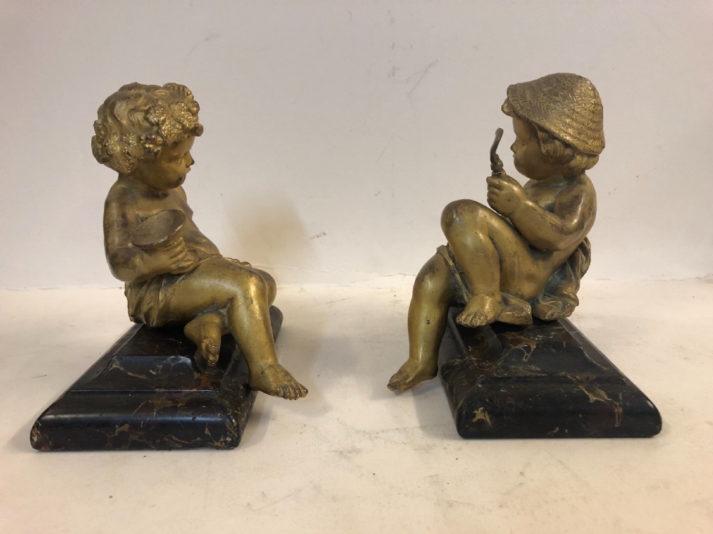 Pair of gilt metal cherub ornaments on marble bases View IV