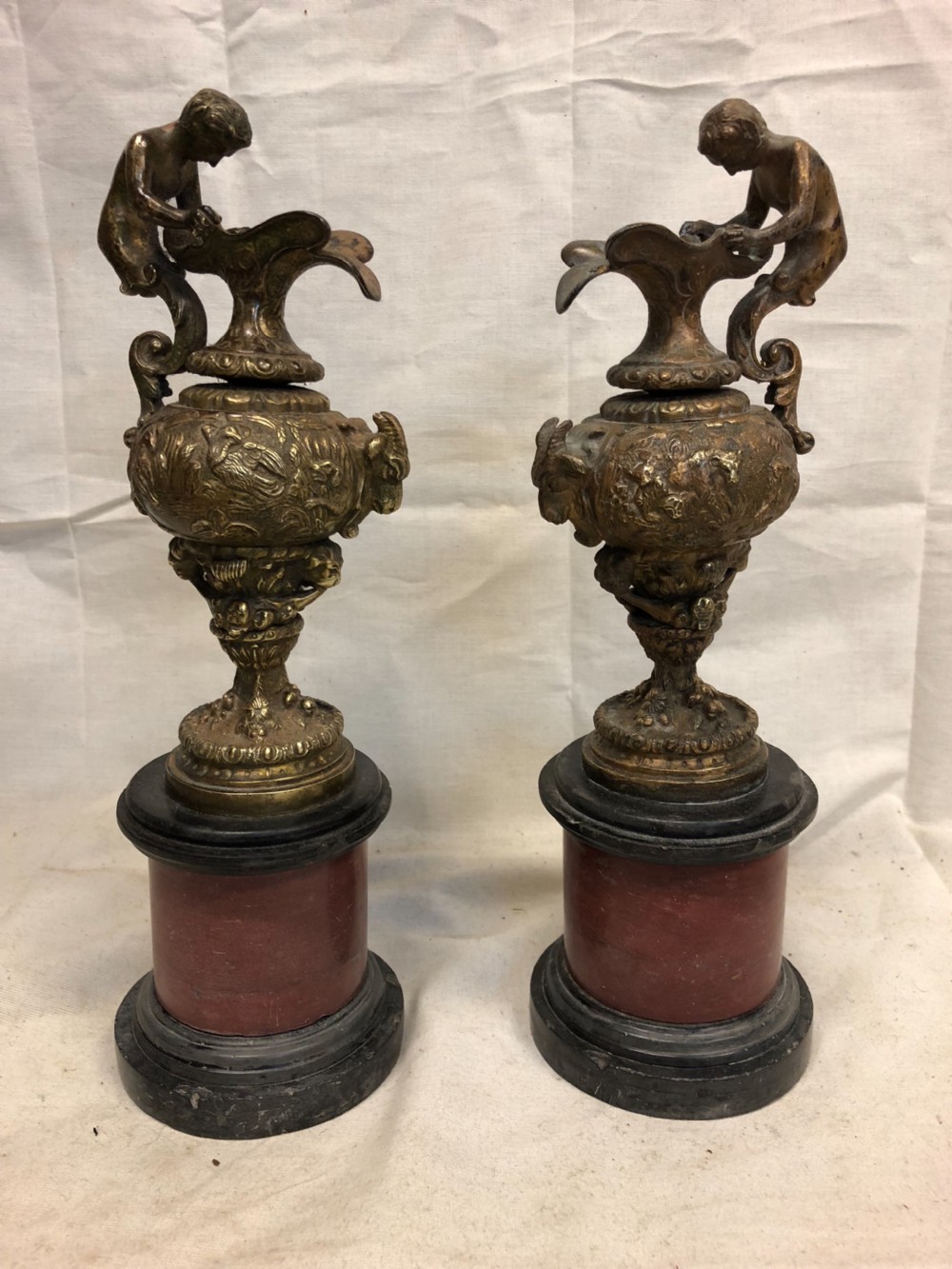 Pair of Classical gilt bronze urns on marble bases 