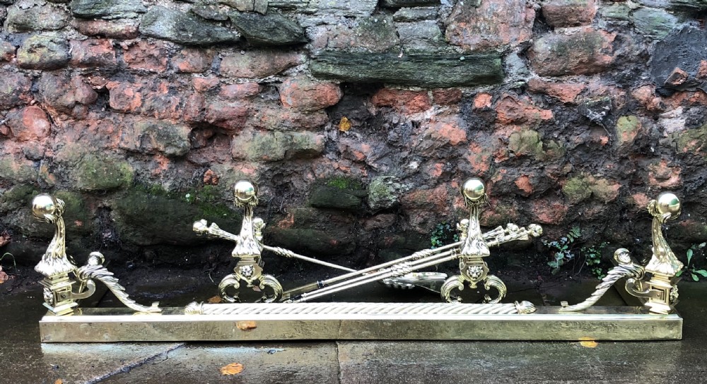 C19th brass fender complete with matching Andirons and fire irons  View II