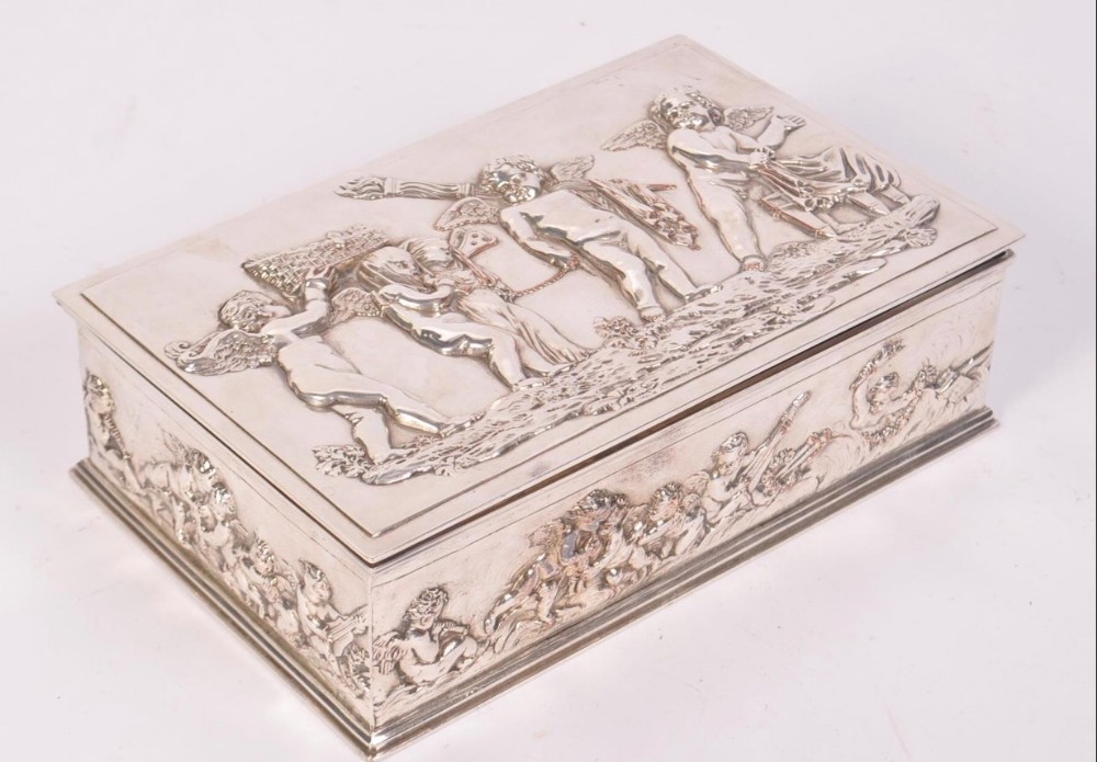 A silver plated box with cavorting cherubs 
