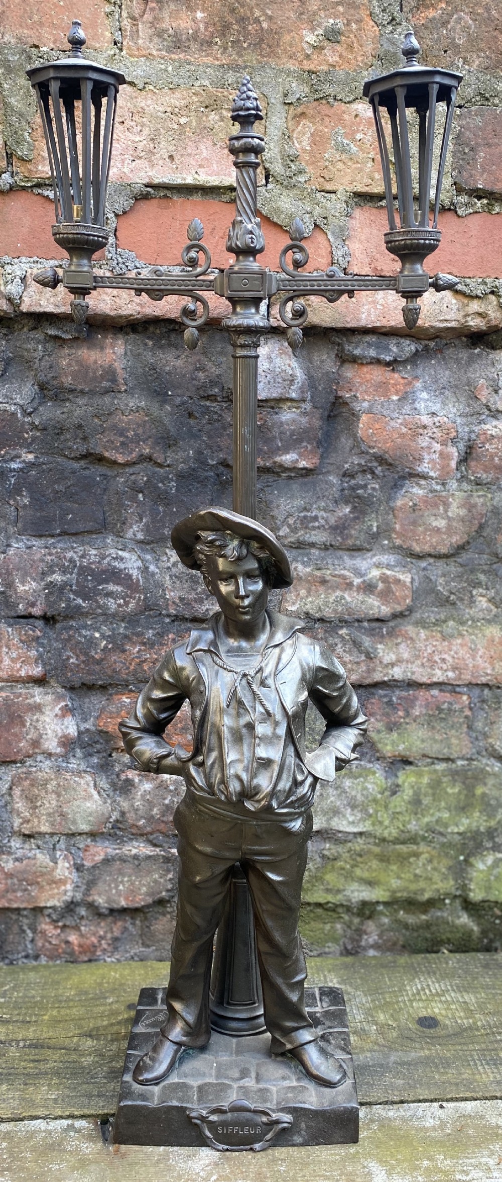 C19th table lamp modelled as a whistling boy leaning against a lamppost 