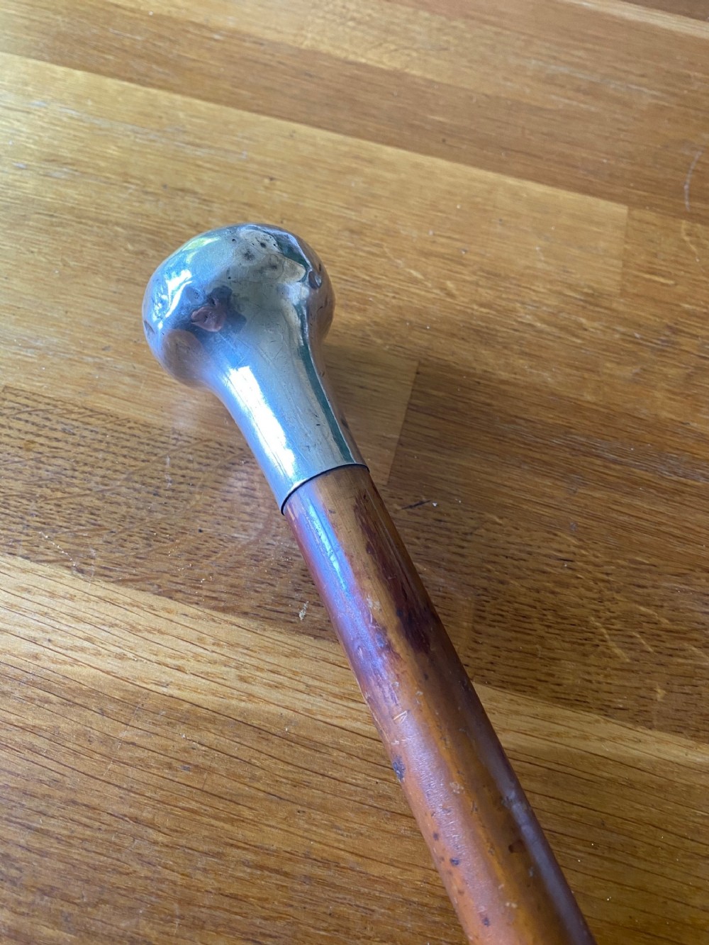 A bulbous white metal topped cane monogrammed RM or MR