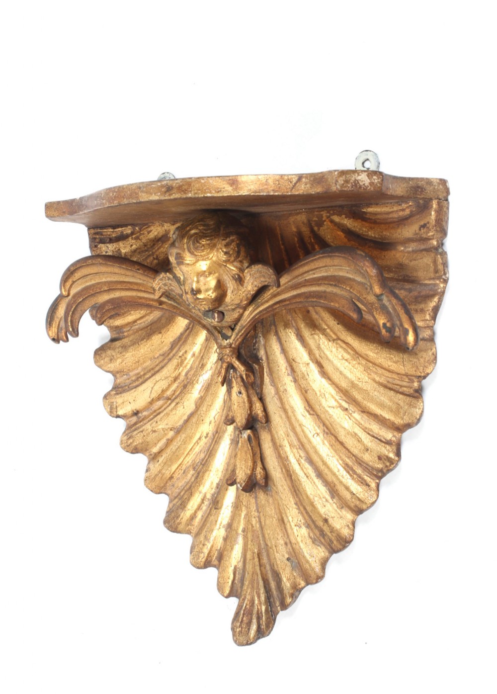 An 18th-century carved giltwood wall bracket featuring a central winged cherub head set against a fluted shell backboard.