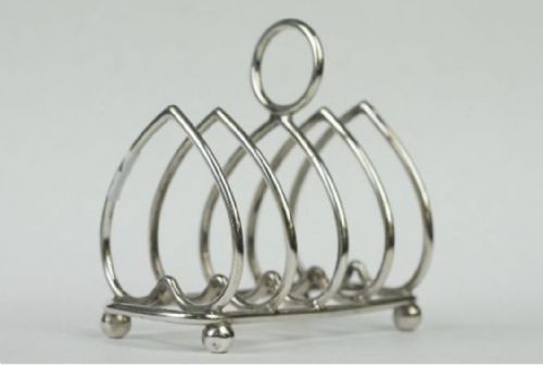 fig 1. A pair of silver-toned metal toast racks featuring heart-shaped wire dividers, ball feet, and ring-shaped top handles.