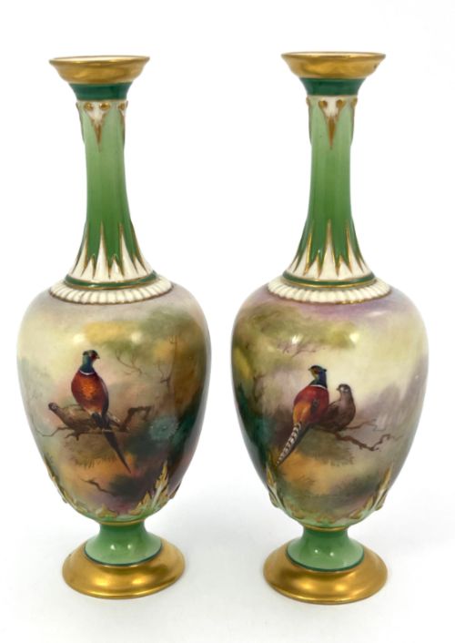 fig 1. A pair of Royal Worcester porcelain vases featuring hand-painted pheasants, slender green necks, flared rims, and gilded pedestal feet.