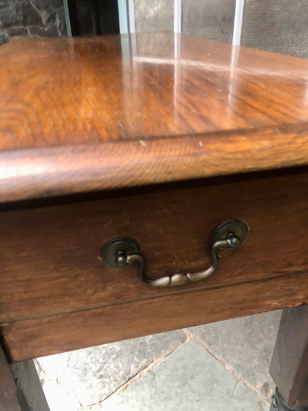 An antique oak chapel table featuring a rectangular drop-leaf top, a single end drawer with a metal handle, and dark turned reeded legs. View II