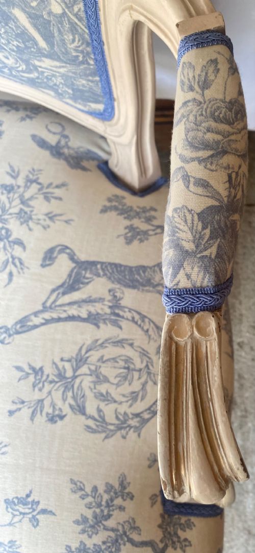 A pair of 19th-century French salon armchairs with off-white painted wooden frames, cabriole legs, and blue pastoral Toile de Jouy pattern upholstery. View V