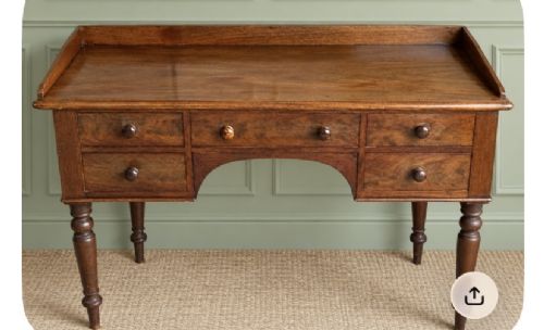 A Victorian mahogany writing desk featuring five drawers with turned knobs, turned legs, an arched kneehole, and a low gallery upstand. View II