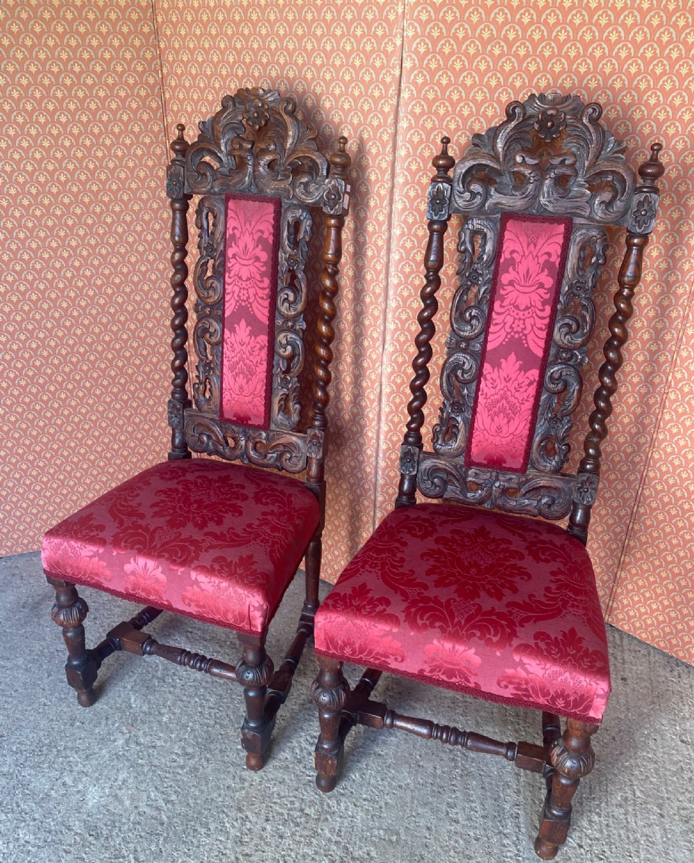 A pair of high-backed carved oak hall chairs featuring elaborate scrollwork, barley twist pillars, and red pattern damask upholstery. View IX