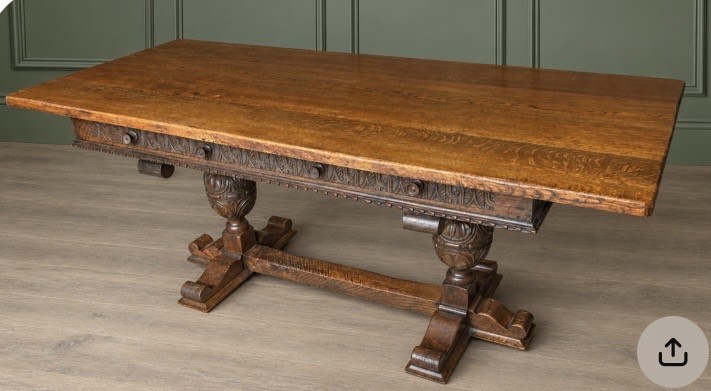 A rectangular solid oak refectory dining table featuring a carved frieze, carved bulbous turned legs, and a low stretcher base. View II