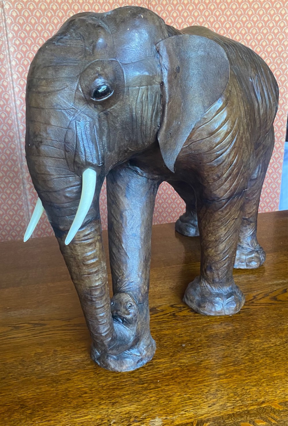 A pair of hand-crafted dark brown leather elephant statues standing with raised trunks and light-coloured tusks. View VIII
