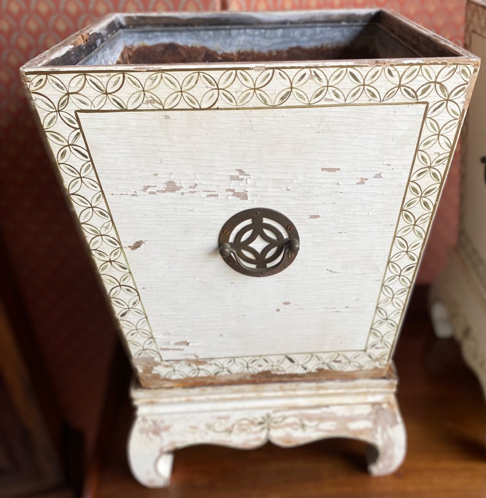 A pair of square cream painted wooden planters featuring raised figural motifs and banana palm tree designs on stepped bases with removable metal liners. View II
